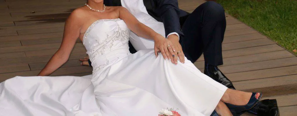 white A-line gown featuring a fitted, subtly ruched bodice with intricate beaded or embroidered detailing at the empire waist.